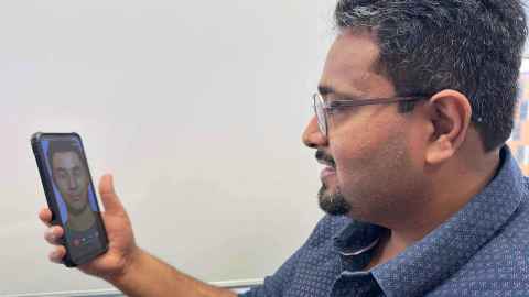 Kunal looks at his phone screen with an image of Toku Hoa