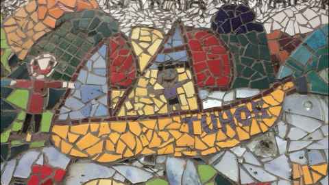 A mosaic featuring a boat called 'Tuhoe' in colourful tiles sailing on a sea with a person on board.