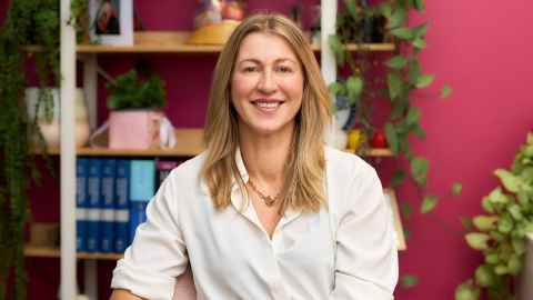 Merryn stands in front of a bookcase
