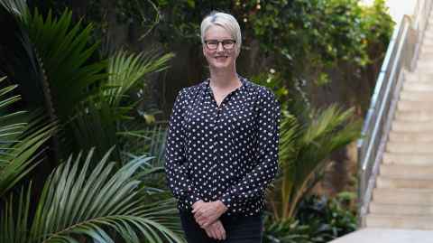 Dr Kate Kersey in front of a garden and stairs.