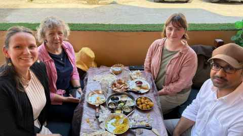Judith Littleton and Caitlin Smith (back) at a traditional Bahraini breakfast with Dr. Salman Almahari and Melanie Muenzner (front) from the Bahrain Authority for Culture and Antiquities. 