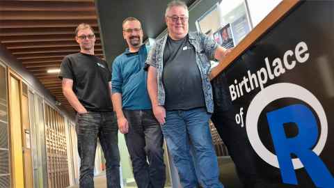  Associate Professor Paul Murrell, Associate Professor Simon Urbanek and Professor Thomas Lumley pose in the Department of Statistics next to a sign saying, Birthplace of R
