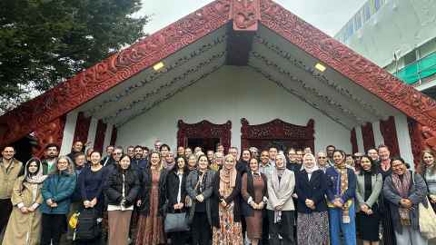 An audience sitting inside Waipapa Marae at the University of Auckland, attending a refugee event.