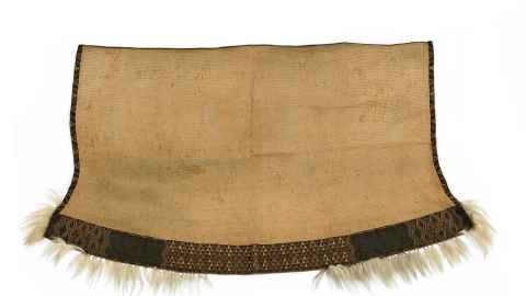 Cloak or patea of flax fibre textile with tāniko borders incorporating blue and brown wool. Tassels of dog hair attached to the lower edge. Photo: British Museum