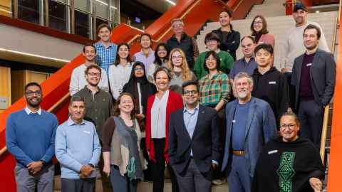 Image of a crowd of symposium attendees posing on a staircase