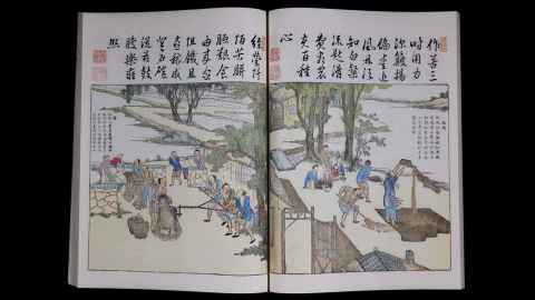 Open illustrated book with Chinese calligraphy and detailed scenes of people working outdoors in a rural landscape.