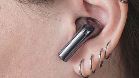 close up of ear with ear bud in it, on ear with four sleeper earrings. 