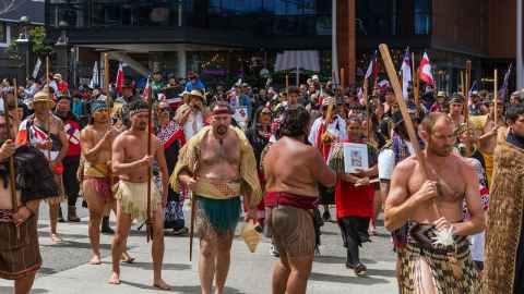 A large gathering of participants, dressed in traditional and contemporary attire, marches through the streets of Wellington as part of the Hikoi mo Te Tiriti . Getty images. 