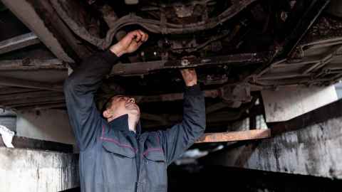 Image of mechanic working on the undercarriage of a car