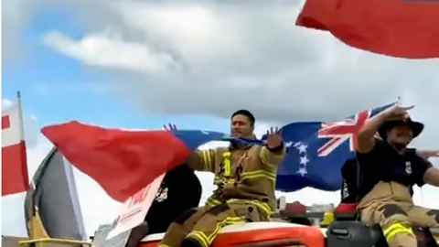 Image of Fire truck and officers with several Pacific nation flags