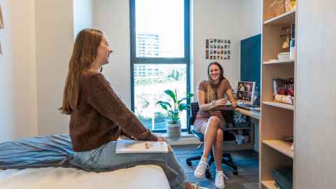 Two students chatting in an accommodation room.