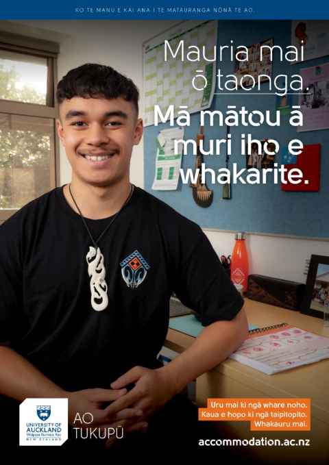 Nardo sits at his desk chair and slightly leans against the desk. He smiles at the camera and is wearing his taonga. Main text reads "Mauria mai ō taonga. Mā mātou ā muri iho e whakarite. Uru mai ki ngā whare noho. Kaua e hopo ki ngā taipitopito. Whakauru mai."