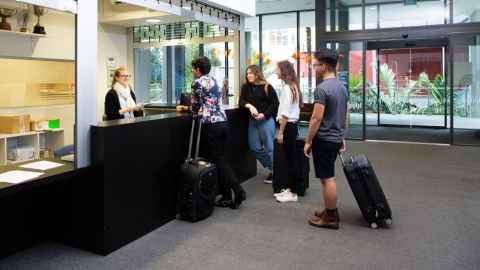 Group of four people being welcomed by the UHT receptionist