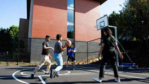 Four people playing basketball at Grafton Hall.