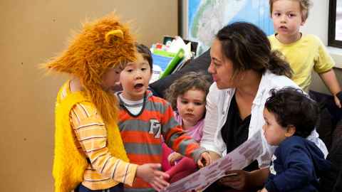 Group of children playing and interacting with a centre staff member.