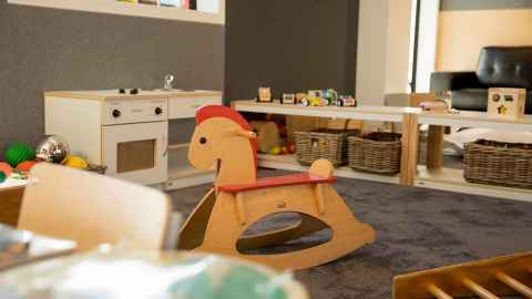 Children's indoor play space with a rocking horse toy.