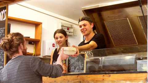 Two food truck staff serving a customer