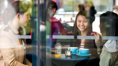 students drinking coffee and chatting in a cafe