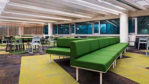 Inside the Te Kāuta Student Kitchen and Lounge space with green sofas and tables and chairs set up
