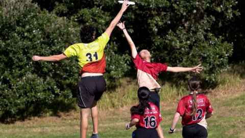 students playing interfaculty ultimate frisbee