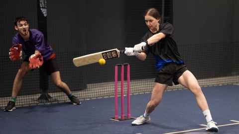 Students playing indoor cricket