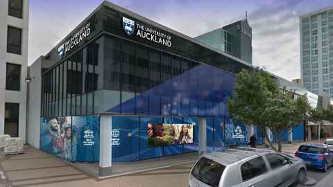 A modern building with a sign saying 'University of Auckland' on it.