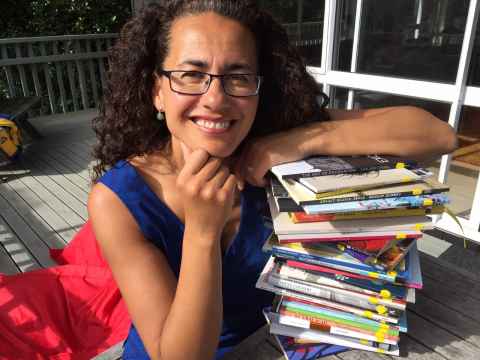 Professor Selina Tusitala Marsh with a stack of books.