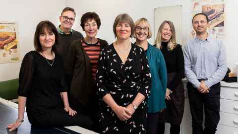 A group of five women and two men, smiling.