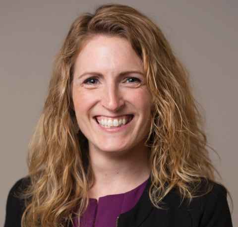 A fair-haired woman, smiling broadly.