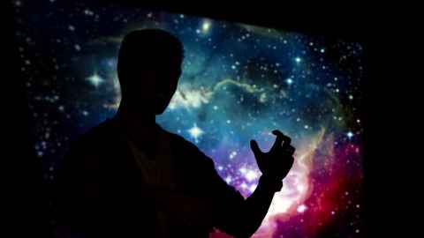Silhouette of a person in front of an image of space.