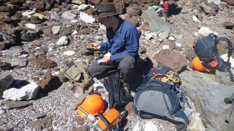 PhD student Geoff Lerner studying volcanic rock.