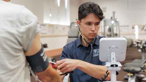 Exercise science student conducting pulse test.