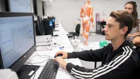Exercise science students looking at a computer monitor