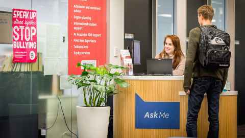 A student standing in front of an advisor