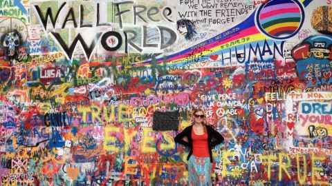 Student standing in front of graffiti art wall. 