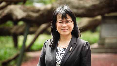 An image of Professor Siew-Young Quek against a forest green background. 