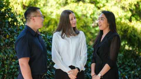 Three doctoral candidates chatting at the University of Auckland's beautiful City Campus.