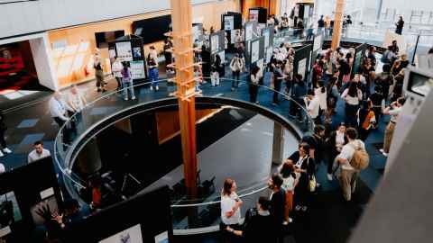 An aerial view of the annual SGS Research Showcase at the University of Auckland, featuring academic posters and research images created by doctoral candidates.