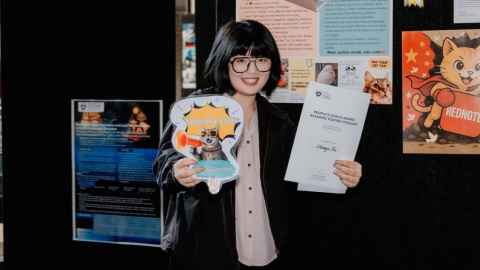 Chenyu Ni standing in front of her research poster