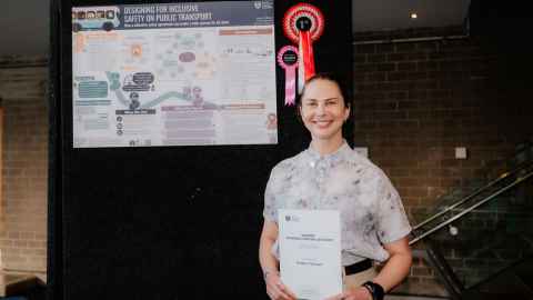 Chenyu Ni standing in front of her research poster