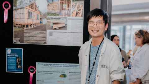 Martin Cheng standing in front of his research poster
