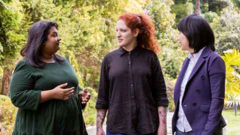 Three doctoral candidates chatting at the University of Auckland's beautiful City Campus.