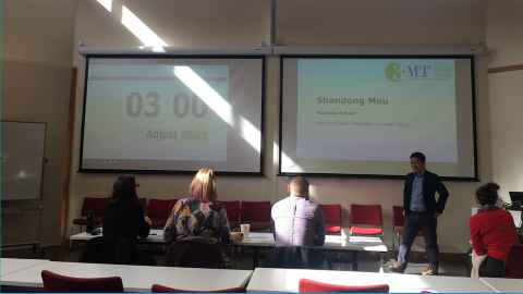 Shandong about to start his 3MT presentation, standing at the front of a lecture theatre.