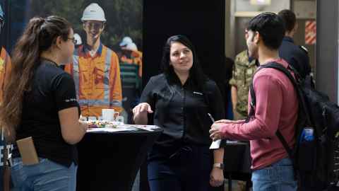 A student talking to an employer representative at a STEM expo