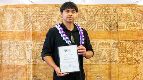 Ethan Andrews holding a framed Tupu Ake completion certificate. 