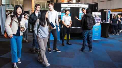 Students waking around employer stalls at a career expo