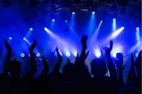 People clubbing with hands in the air and blue lights