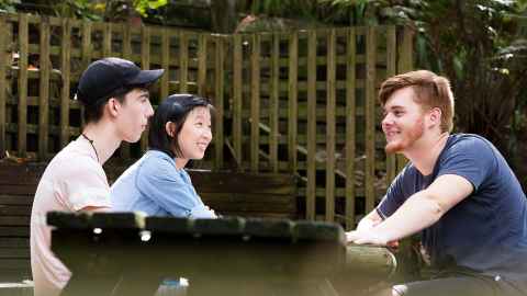 Students chat at a table.