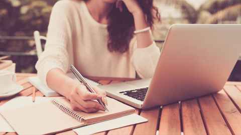 Image of a person sitting in front of their laptop.