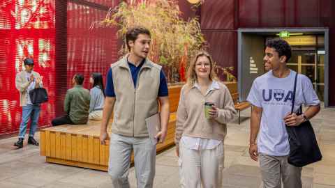 Three international students walking and chatting